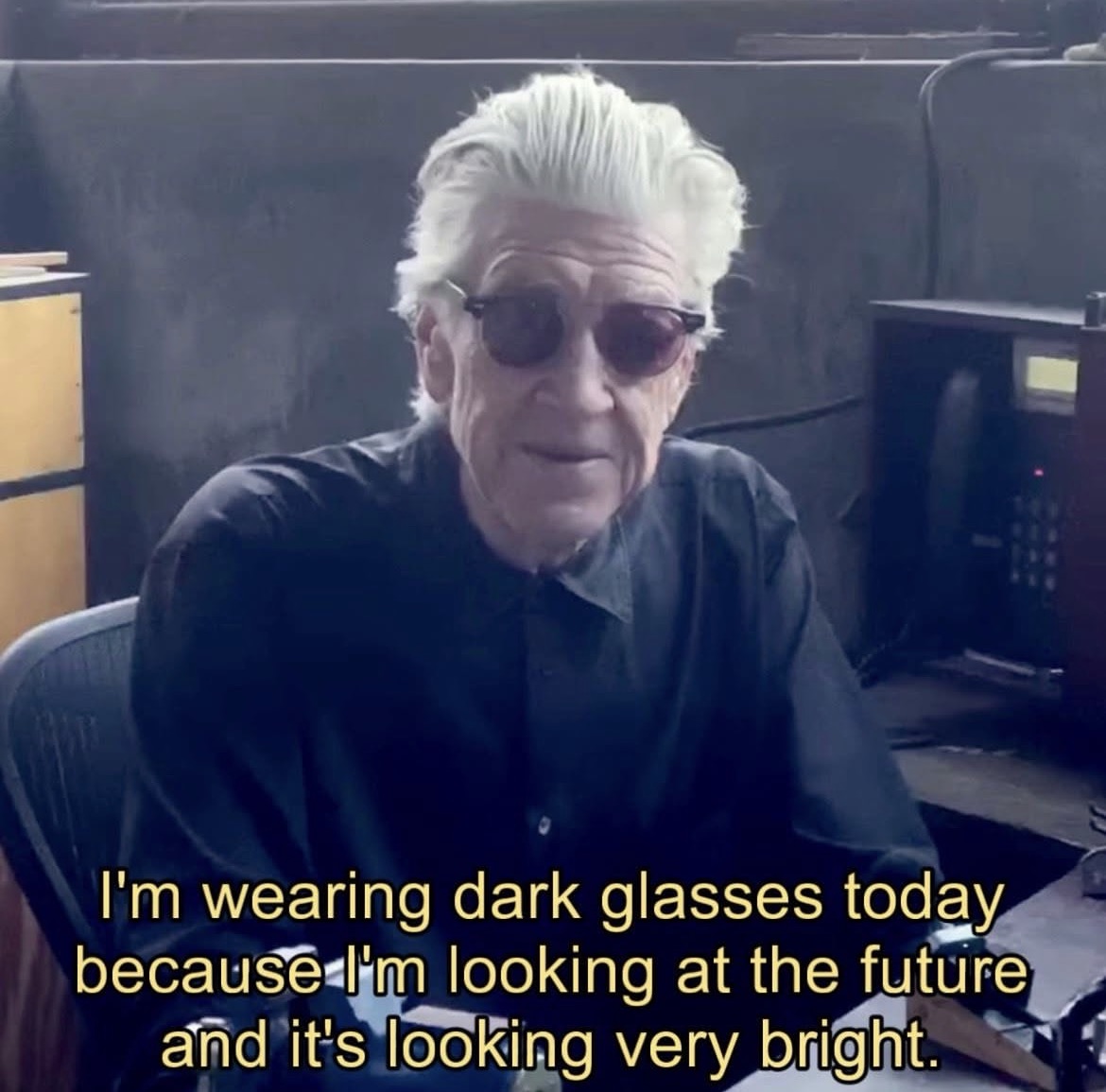 David Lynch in dark glasses captioned 'I'm wearing dark glasses today because I'm looking at the future and it's looking very bright.'