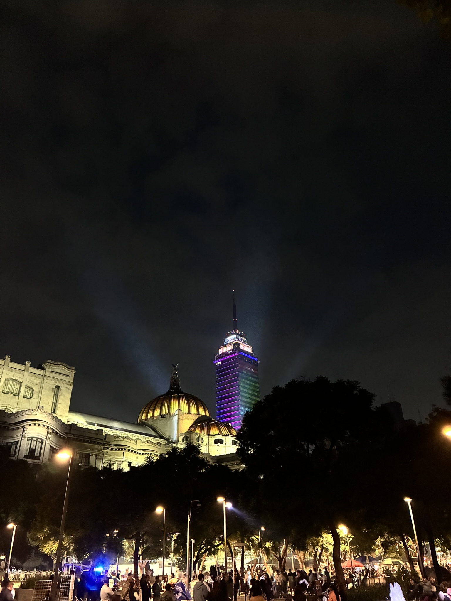 Palacio de Bellas Artes lit up at night with the Torre Latinoamericana skyscraper behind it