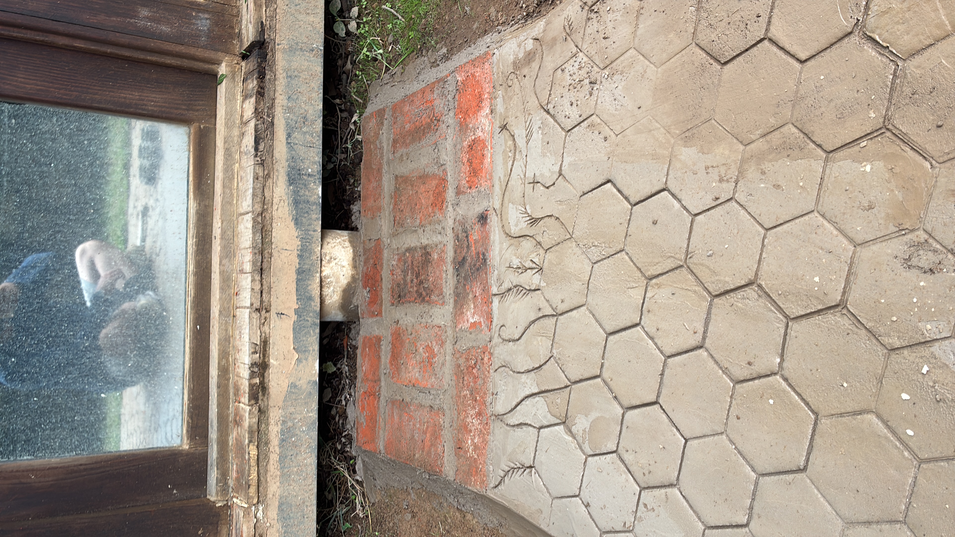 Close-up of a stone pathway with hexagonal tiles and a carved snake design