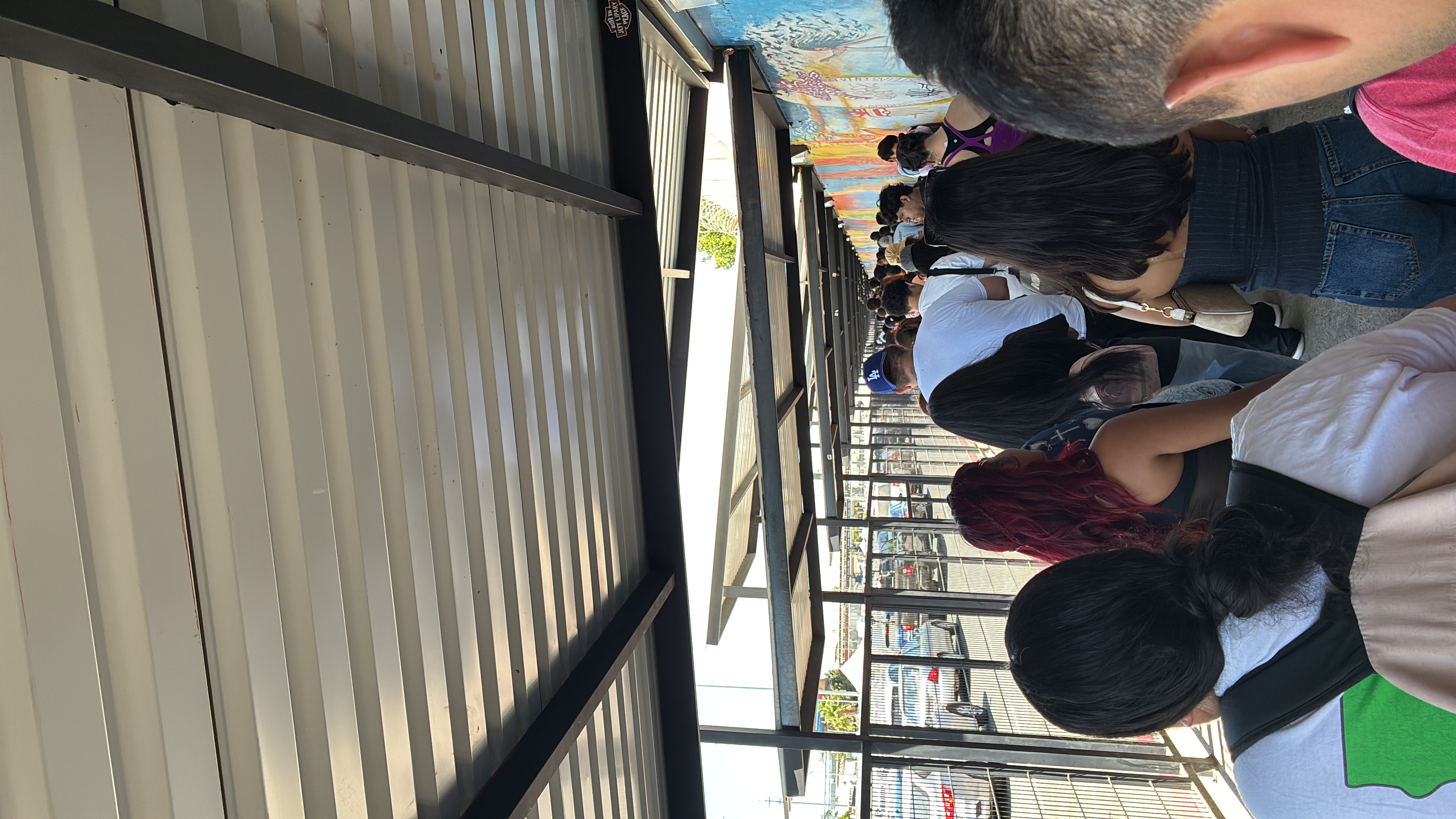 A group of friends hanging out at a rooftop bar with colorful murals