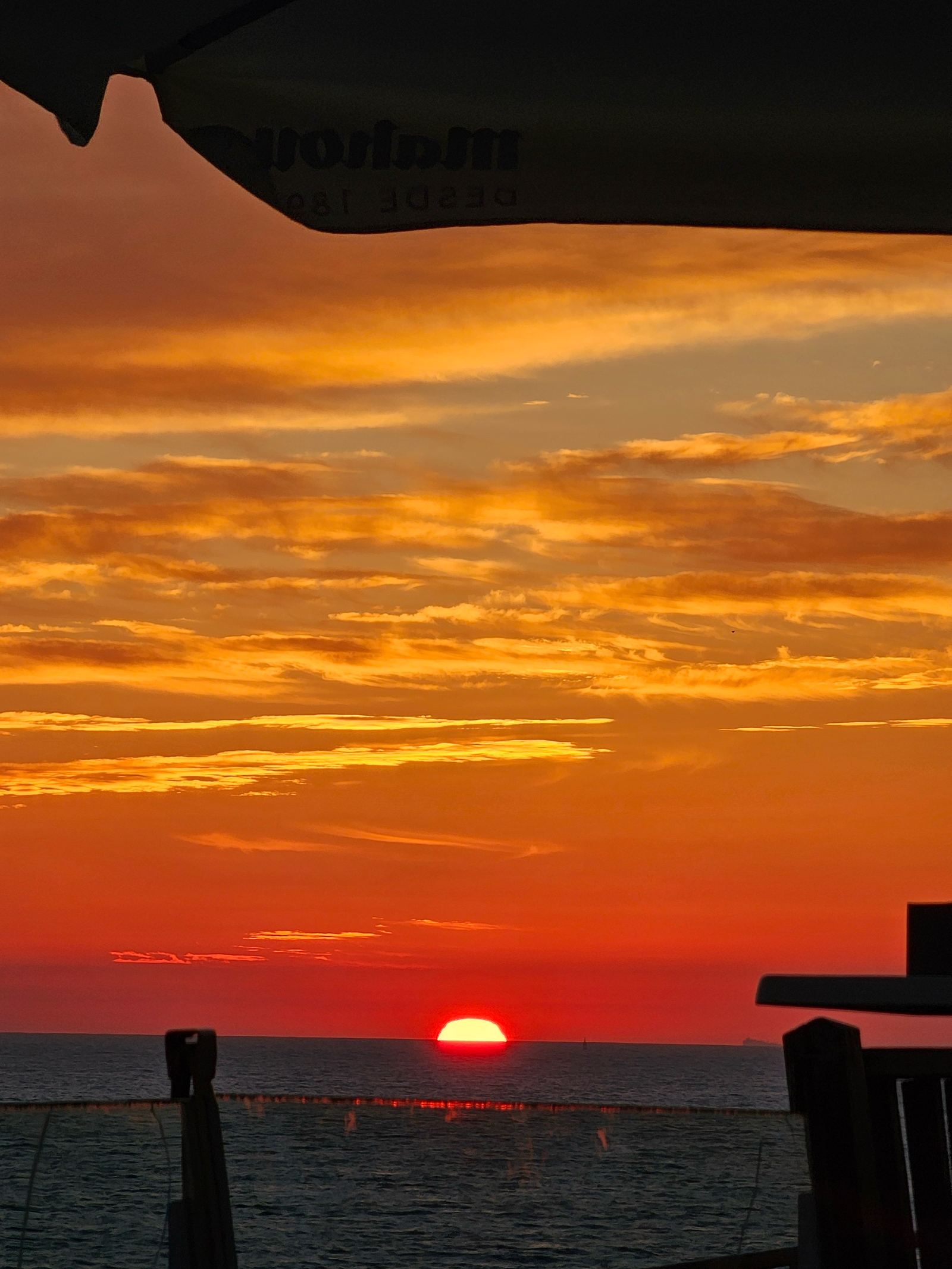 The sun setting over the ocean in Cádiz, seen from a beachside terrace